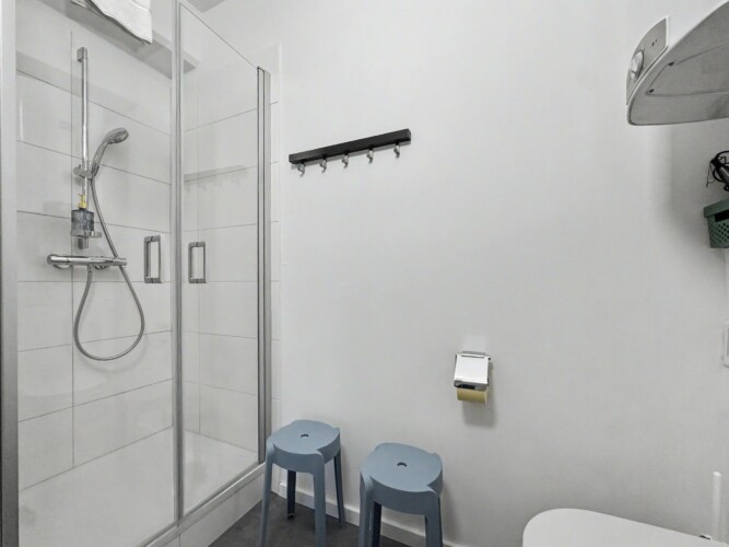 Draupromenade 12 Villach – Top 1 Türkis – glass shower cubicle with hand shower on a rail, hook rail and two stools