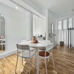 Draupromenade 12 Villach – Top 2 Gold – round dining table with four chairs and full-length arched mirror