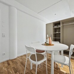 Draupromenade 12 Villach – Top 2 Gold – dining table beside the open wardrobe with hanging rail, hangers and shelves