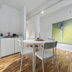 Draupromenade 12 Villach – Top 4 Pink – kitchenette with sink, two hobs, fridge and capsule coffee machine next to the dining table