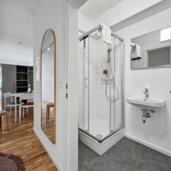 Draupromenade 12 Villach – Top 4 Pink – glass shower cubicle and wall-hung washbasin seen from the hallway