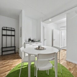 Draupromenade 12 Villach – Top 5 Grasgrün – entrance area with black coat rack and bench next to dining table and kitchenette