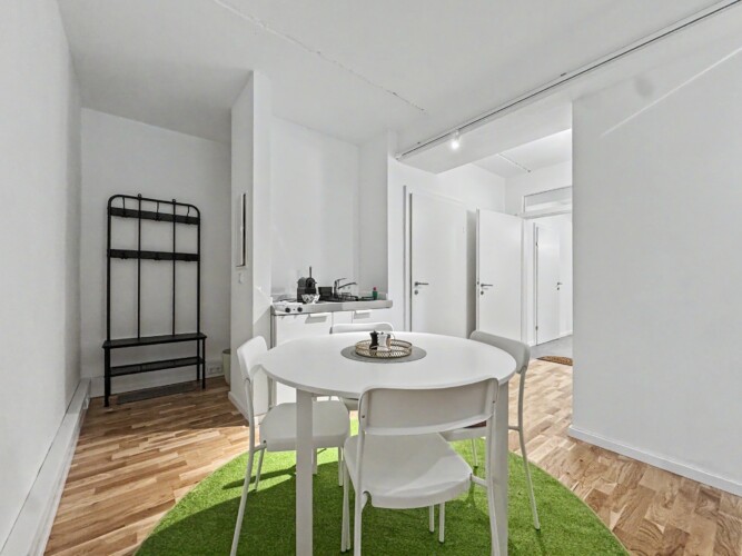 Draupromenade 12 Villach – Top 5 Grasgrün – entrance area with black coat rack and bench next to dining table and kitchenette