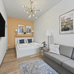 Cozy living area with wall-mounted TV and Sputnik ceiling lamp in Vienna short-term rental