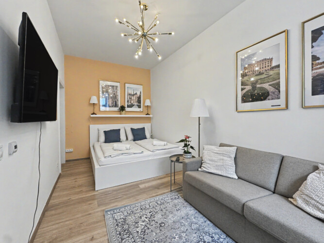 Cozy living area with wall-mounted TV and Sputnik ceiling lamp in Vienna short-term rental