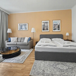 Spacious living room with parquet flooring and beige accent walls in large Vienna Altbau apartment for 8 guests