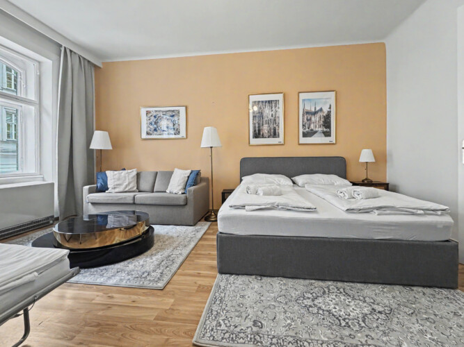 Spacious living room with parquet flooring and beige accent walls in large Vienna Altbau apartment for 8 guests