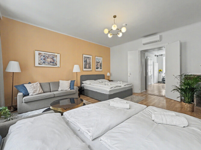 Large dining table set for nine guests in open-plan Vienna Altbau apartment