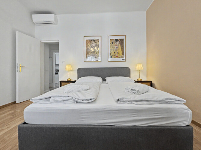 Bedroom detail with bedside lamp and parquet flooring in elegant Vienna holiday rental