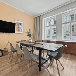 Second bedroom with double bed and beige accent wall in Vienna Altbau group apartment