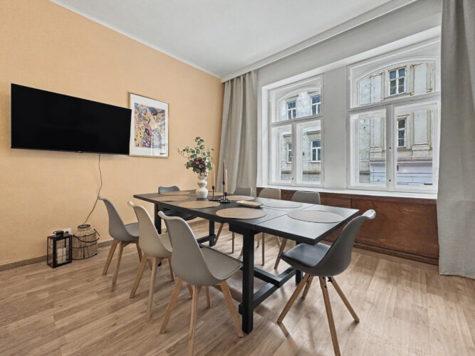 Second bedroom with double bed and beige accent wall in Vienna Altbau group apartment