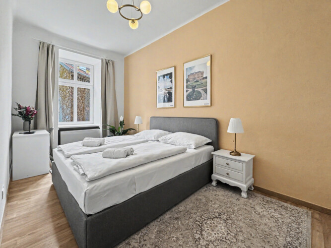 Third bedroom detail with reading lamp and warm lighting in Vienna short-term rental